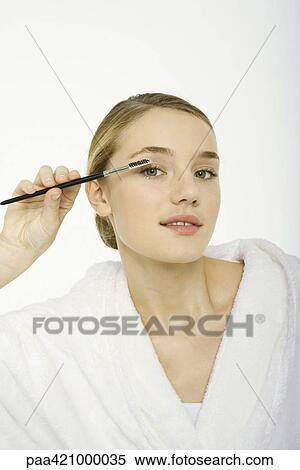 Stock Photography - Teenage girl brushing eyelashes. Fotosearch