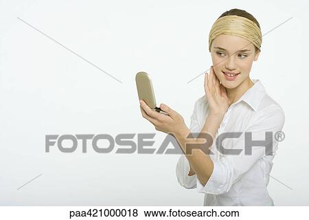 Teenage girl looking at self in hand mirror View Large Photo Image Stock Photo - Teenage girl looking at self in hand mirror. Fotosearch