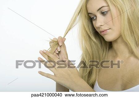Teenage girl looking at strand of hair View Large Photo Image Stock Image - Teenage girl looking at strand of hair. Fotosearch