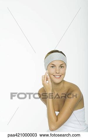 Young woman applying moisturizer to face View Large Photo Image Stock Image - Young woman applying moisturizer to face. Fotosearch