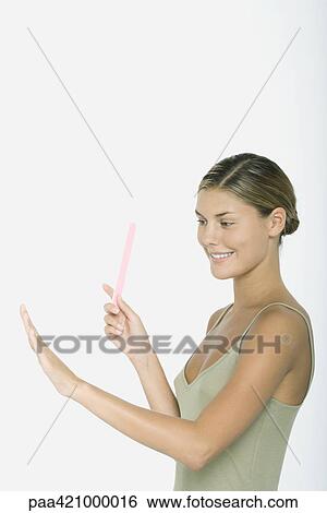 Young woman holding nail file, admiring nails View Large Photo Image Stock Photograph - Young woman holding nail file, admiring nails. Fotosearch