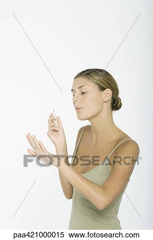 Young woman holding nail polish wand, blowing on nails View Large Photo Image Stock Photography - Young woman holding nail polish wand, blowing on nails. Fotosearch