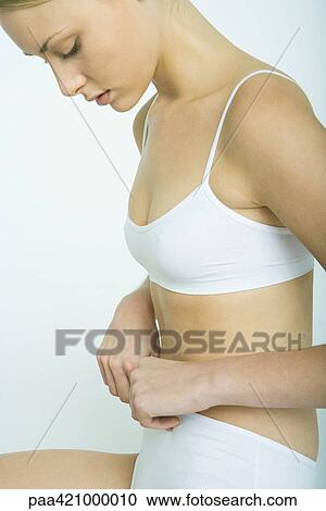 Young woman holding waist band of underwear, looking down View Large Photo Image Stock Image - Young woman holding waist band of underwear, looking down. Fotosearch