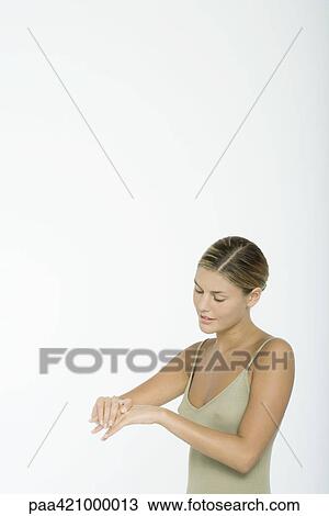 Young woman moisturizing hands View Large Photo Image Stock Image - Young woman moisturizing hands. Fotosearch