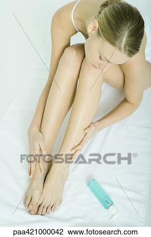 Young woman moisturizing legs, high angle view View Large Photo Image Stock Image - Young woman moisturizing legs, high angle view. Fotosearch