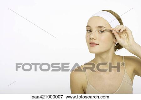 Young woman plucking eyebrows View Large Photo Image Stock Photo - Young woman plucking eyebrows. Fotosearch