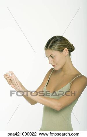 Stock Image - Young woman polishing nails. Fotosearch