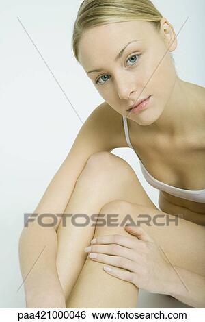 Young woman sitting in underwear, touching legs View Large Photo Image Stock Photograph - Young woman sitting in underwear, touching legs. Fotosearch