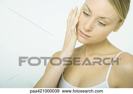 Young woman touching cheek View Large Photo Image Stock Photo - Young woman touching cheek. Fotosearch