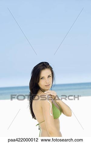 Woman applying sunscreen to arm on beach, side view View Large Photo Image Stock Image - Woman applying sunscreen to arm on beach, side view. Fotosearch