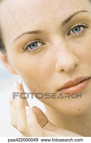 Woman applying sunscreen to face, close-up View Large Photo Image Stock Photo - Woman applying sunscreen to face, close-up. Fotosearch
