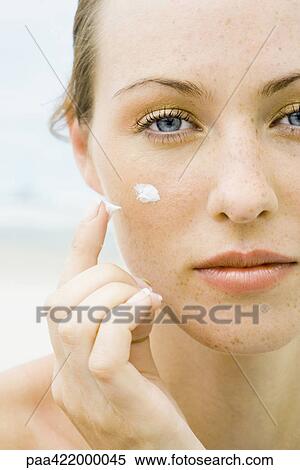 Woman applying sunscreen to face, close-up View Large Photo Image Stock Photography - Woman applying sunscreen to face, close-up. Fotosearch
