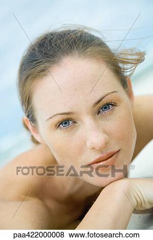 Woman lying on beach, looking at camera, head and shoulders, close-up View Large Photo Image Stock Photo - Woman lying on beach, looking at camera, head and shoulders, close-up. Fotosearch