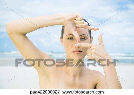 Woman on beach making finger frame around eye, head and shoulders View Large Photo Image Stock Photo - Woman on beach making finger frame around eye, head and shoulders. Fotosearch