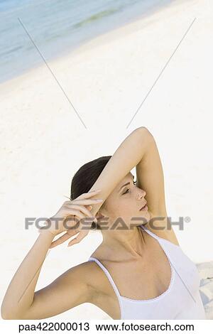 Woman on beach, shading eyes with arm View Large Photo Image Stock Image - Woman on beach, shading eyes with arm. Fotosearch