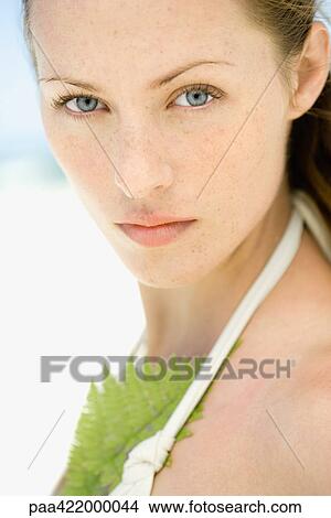 Woman wearing halter top bathing suit, leaf against chest, looking at camera, close-up, portrait View Large Photo Image Picture - Woman wearing halter top bathing suit, leaf against chest, looking at camera, close-up, portrait. Fotosearch