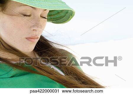 Woman wearing sunhat on beach, eyes closed View Large Photo Image Stock Image - Woman wearing sunhat on beach, eyes closed. Fotosearch