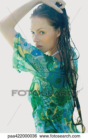 Woman with long wet hair, hand on head, looking over shoulder at camera View Large Photo Image Stock Photograph - Woman with long wet hair, hand on head, looking over shoulder at camera. Fotosearch