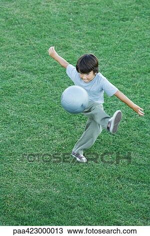 Stock Image - Boy kicking ball. Fotosearch