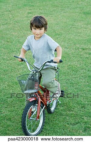Boy on bike, full length View Large Photo Image Stock Photo - Boy on bike, full length. Fotosearch
