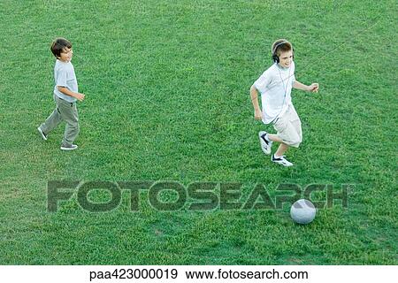 Two boys playing ball on lawn, high angle view View Large Photo Image Stock Photo - Two boys playing ball on lawn, high angle view. Fotosearch