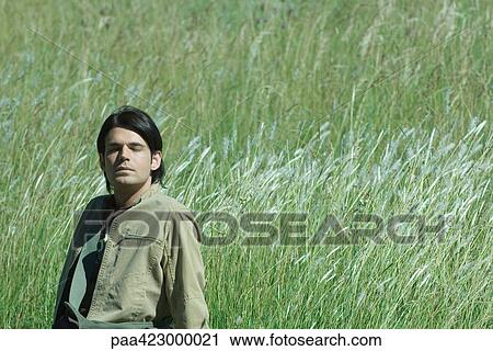 Young man in field, eyes closed View Large Photo Image Stock Image - Young man in field, eyes closed. Fotosearch