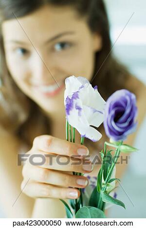 Young woman holding flowers View Large Photo Image Stock Image - Young woman holding flowers. Fotosearch
