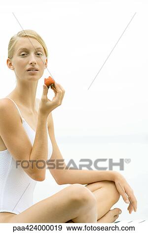 Teenage girl in swimsuit, eating strawberry View Large Photo Image Stock Photo - Teenage girl in swimsuit, eating strawberry. Fotosearch
