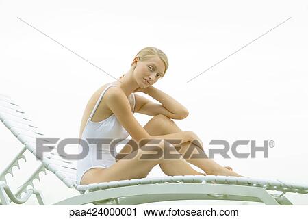 Teenage girl in swimsuit sitting on lounge chair View Large Photo Image Stock Image - Teenage girl in swimsuit sitting on lounge chair. Fotosearch