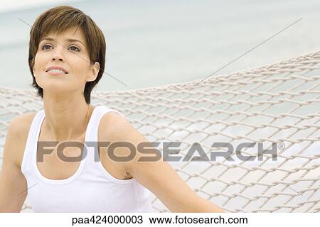 Stock Image - Woman relaxing on hammock. Fotosearch