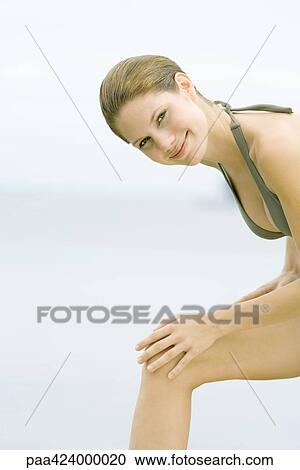 Young woman wearing bathing suit, leaning forward with hands on knee View Large Photo Image Stock Image - Young woman wearing bathing suit, leaning forward with hands on knee. Fotosearch