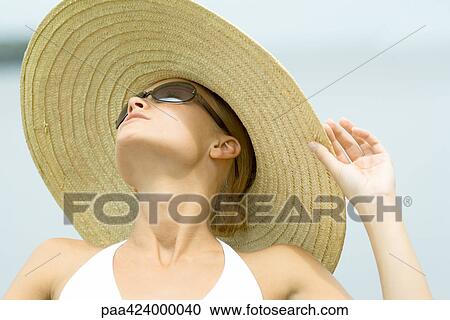 Young woman wearing sunglasses and sunhat, head and shoulders View Large Photo Image Stock Image - Young woman wearing sunglasses and sunhat, head and shoulders. Fotosearch