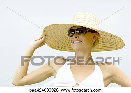 Young woman wearing sunglasses and sunhat, head and shoulders View Large Photo Image Stock Photo - Young woman wearing sunglasses and sunhat, head and shoulders. Fotosearch