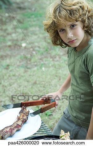 Boy picking up piece of meat with tongs View Large Photo Image Stock Image - Boy picking up piece of meat with tongs. Fotosearch