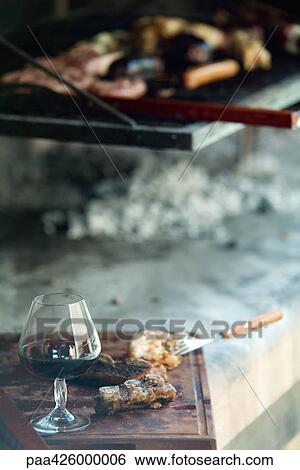 Glass of wine and meet grilling View Large Photo Image Stock Photograph - Glass of wine and meet grilling. Fotosearch