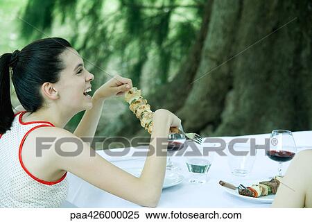 Outdoor meal, teen girl holding kebab, laughing View Large Photo Image Stock Photography - Outdoor meal, teen girl holding kebab, laughing. Fotosearch