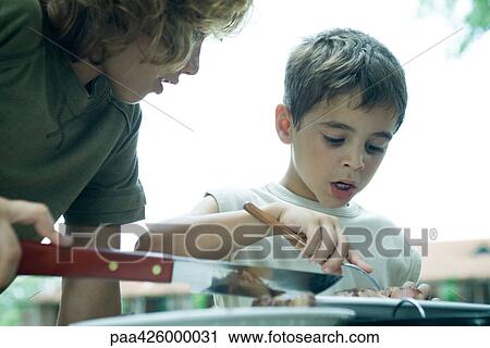 Two boys looking at piece of meat View Large Photo Image Stock Image - Two boys looking at piece of meat. Fotosearch