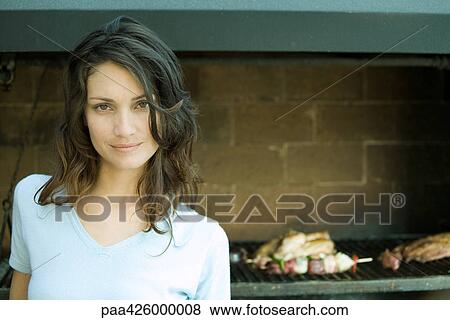 Woman standing in front of barbecue View Large Photo Image Stock Photo - Woman standing in front of barbecue. Fotosearch