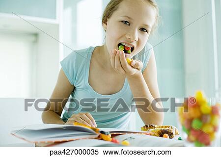 Girl eating junk food while doing homework View Large Photo Image Stock Photography - Girl eating junk food while doing homework. Fotosearch