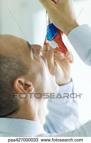 Man holding up package of food above open mouth View Large Photo Image Stock Image - Man holding up package of food above open mouth. Fotosearch