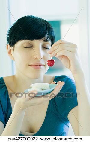 Woman holding up saucer of food and cherry, eyes closed View Large Photo Image Stock Image - Woman holding up saucer of food and cherry, eyes closed. Fotosearch