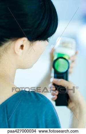 Woman inspecting packaged food with magnifying glass View Large Photo Image Picture - Woman inspecting packaged food with magnifying glass. Fotosearch