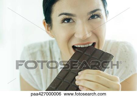 Woman taking bite out of bar of chocolate View Large Photo Image Stock Photograph - Woman taking bite out of bar of chocolate. Fotosearch