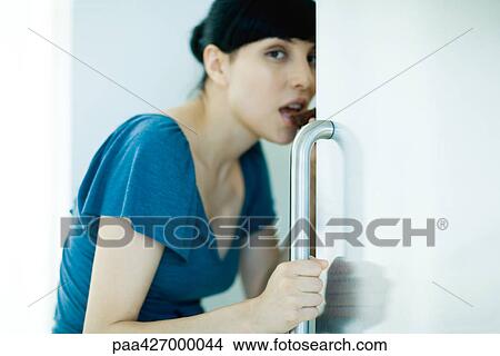 Young woman standing with refrigerator door open, eating piece of cake, looking at camera View Large Photo Image Picture - Young woman standing with refrigerator door open, eating piece of cake, looking at camera. Fotosearch
