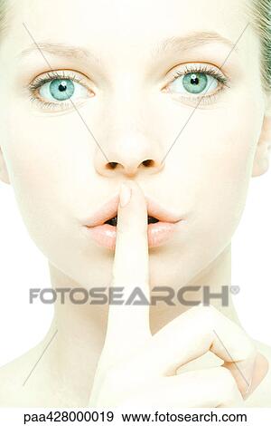 Teenage girl holding finger over lips, close-up, front view View Large Photo Image Stock Photo - Teenage girl holding finger over lips, close-up, front view. Fotosearch