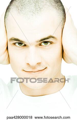 Young man with hands over ears, smiling at camera, close-up, front view View Large Photo Image Stock Photo - Young man with hands over ears, smiling at camera, close-up, front view. Fotosearch