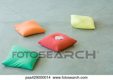 Picture - Cushions on floor, deck of cards on one cushion. Fotosearch