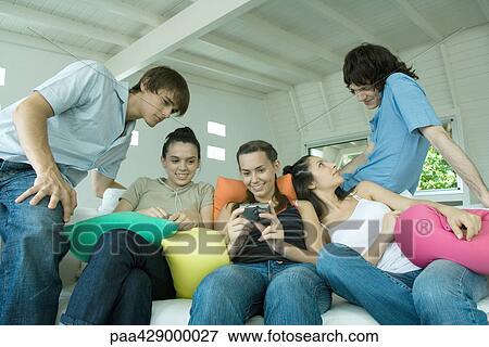 Teenage friends hanging out on sofa View Large Photo Image Stock Photo - Teenage friends hanging out on sofa. Fotosearch
