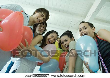 Teenage friends holding balloons View Large Photo Image Stock Photo - Teenage friends holding balloons. Fotosearch