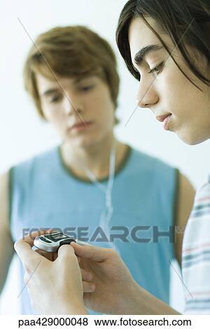 Teenage friends listening to MP3 player together View Large Photo Image Stock Photo - Teenage friends listening to MP3 player together. Fotosearch